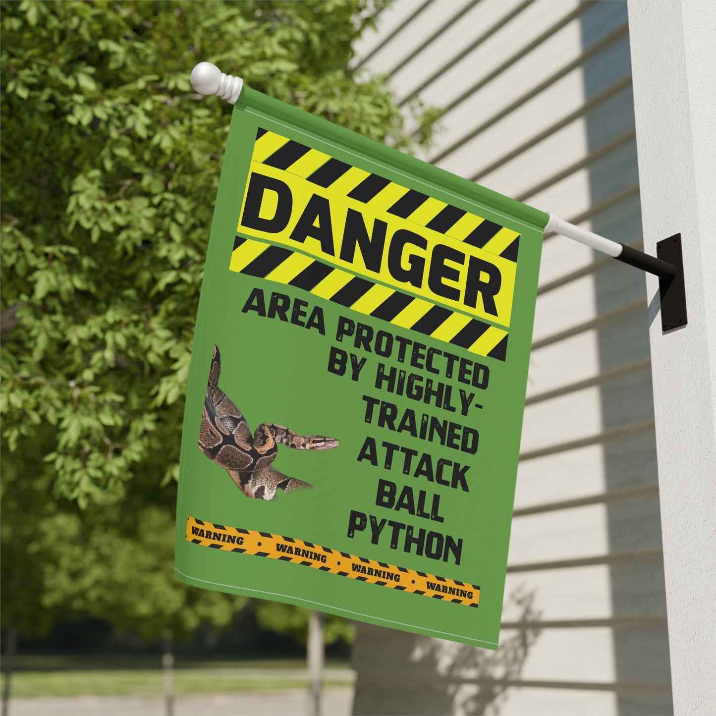 a green and yellow sign with a warning about a highly trained attack ball pythons.