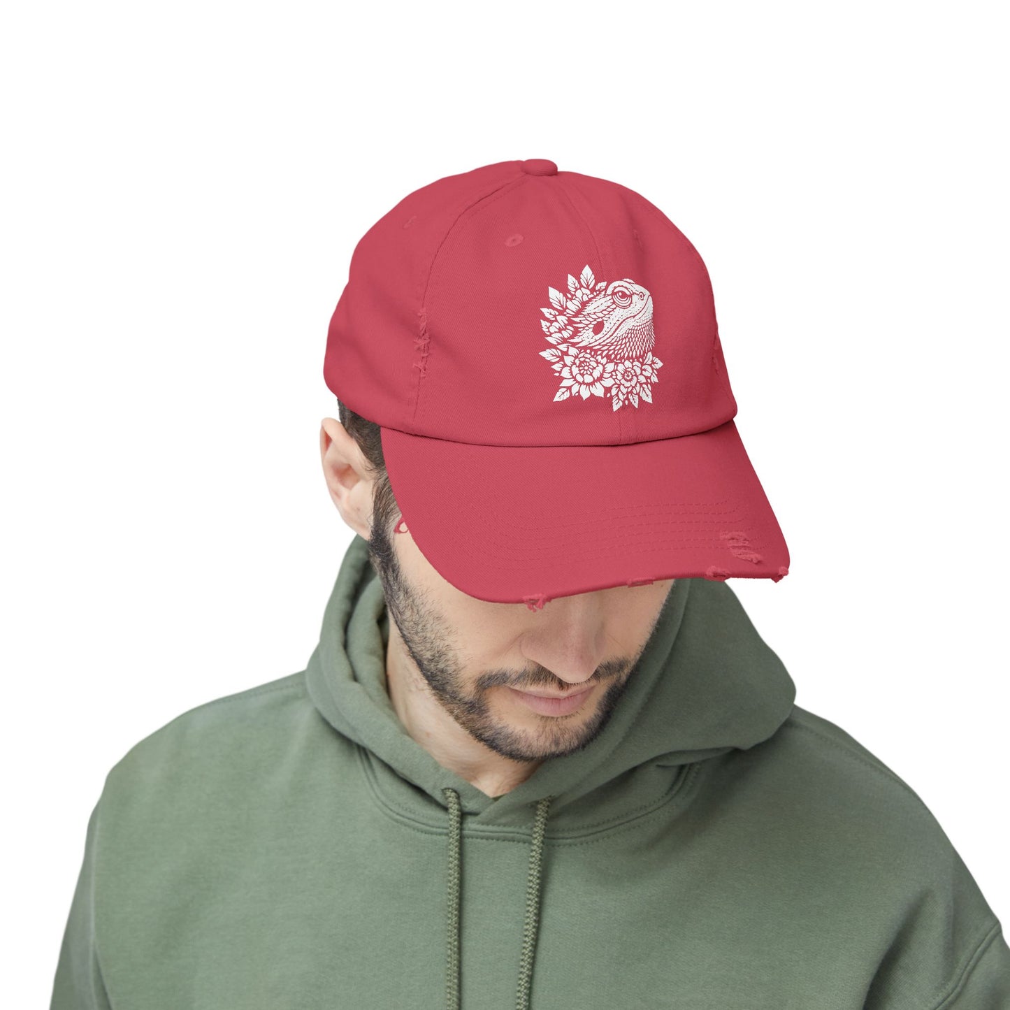 A man wearing a red baseball cap with a white floral design on it.