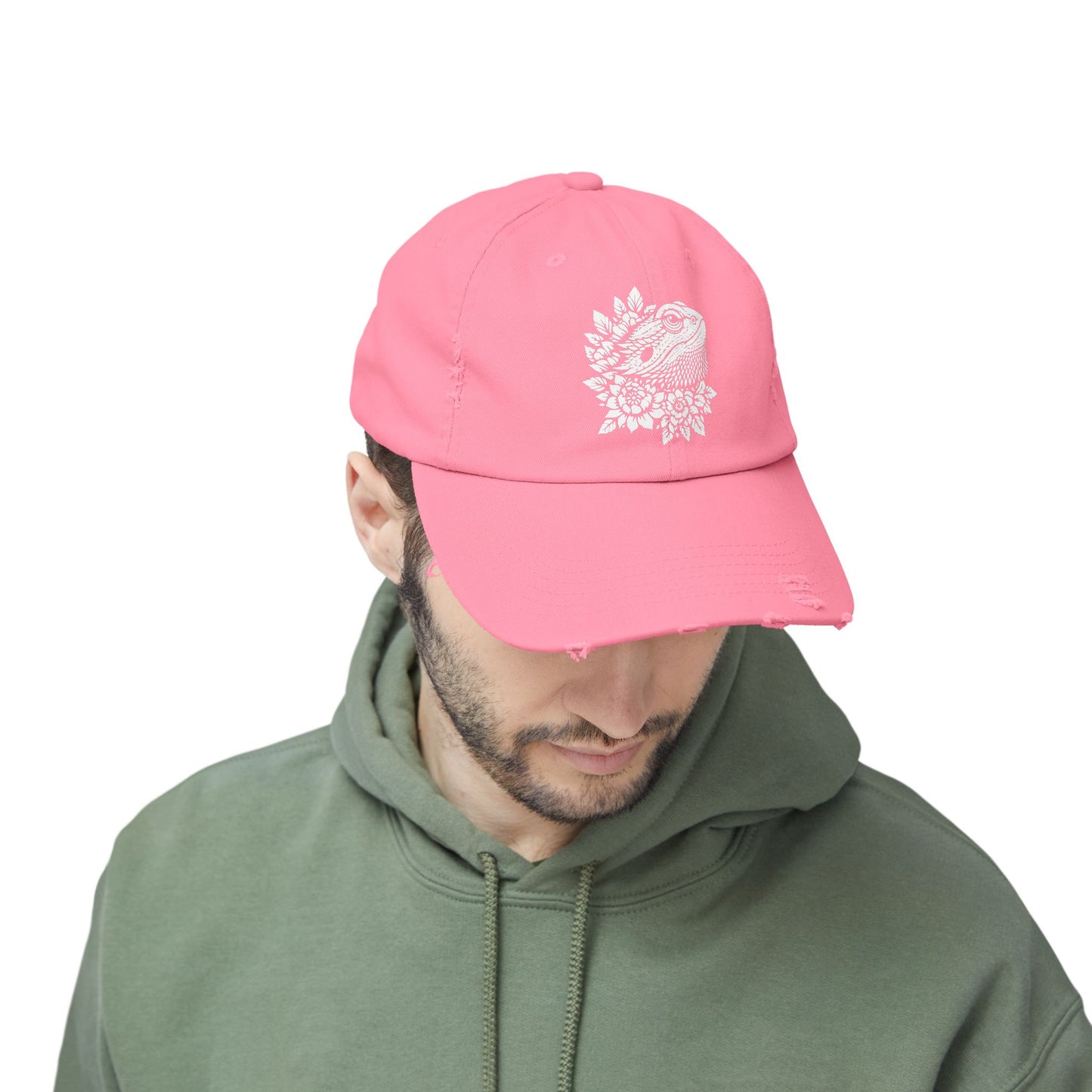 A man wearing a pink baseball cap with a white floral design on it.