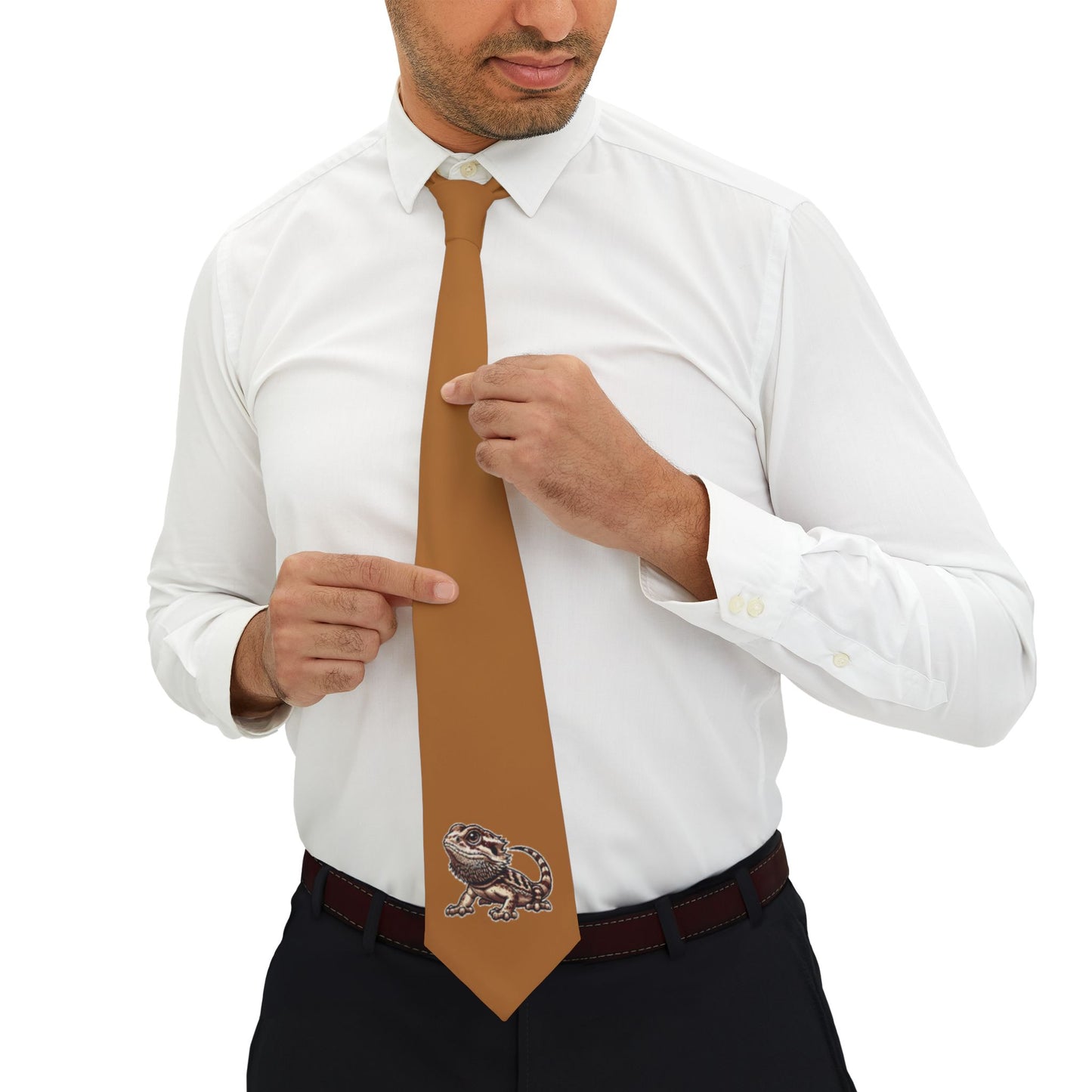 A man in a white shirt and black pants is adjusting his brown tie, which has a graphic of a lizard on it.