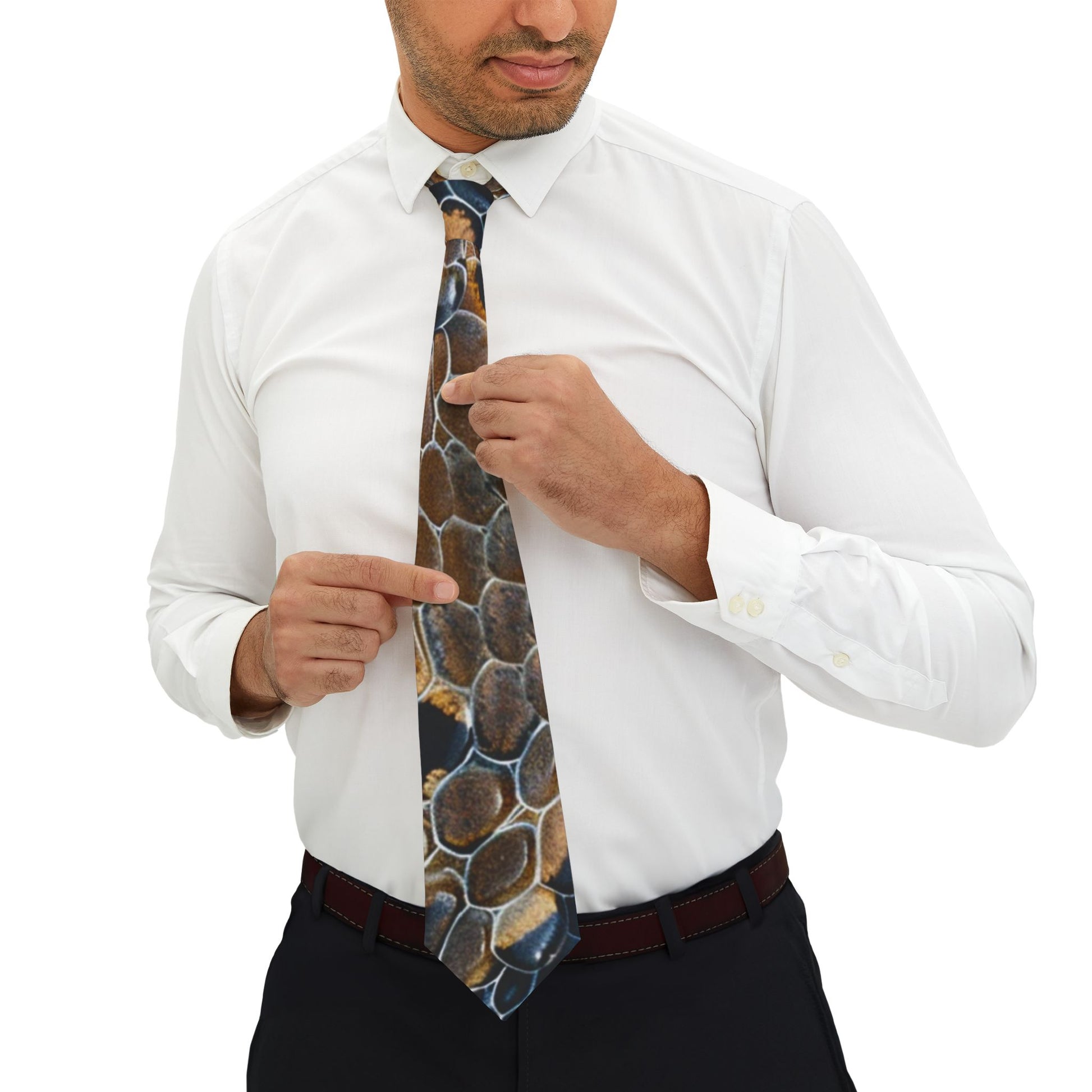 A man in a white shirt and black pants is adjusting his tie, pointing to the pattern on the tie.