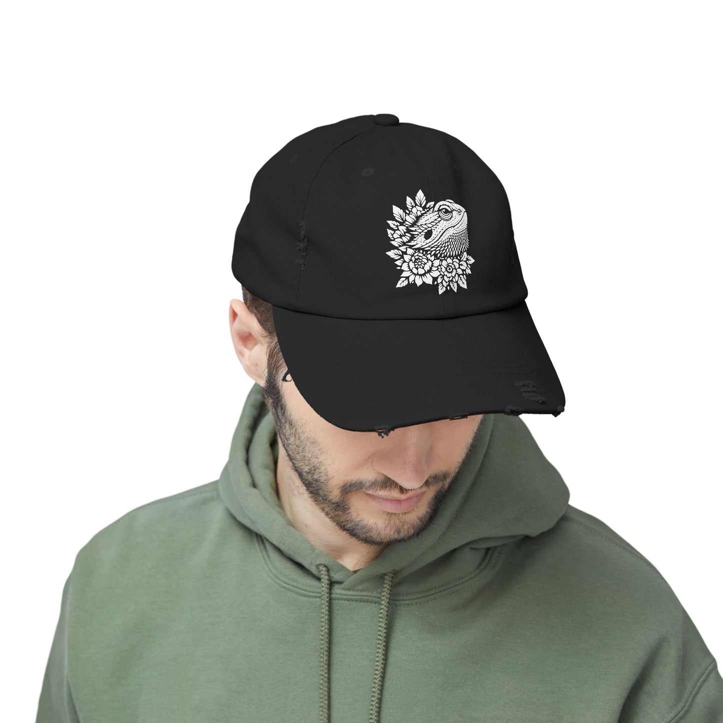 A man wearing a black baseball cap with a white floral design on it.