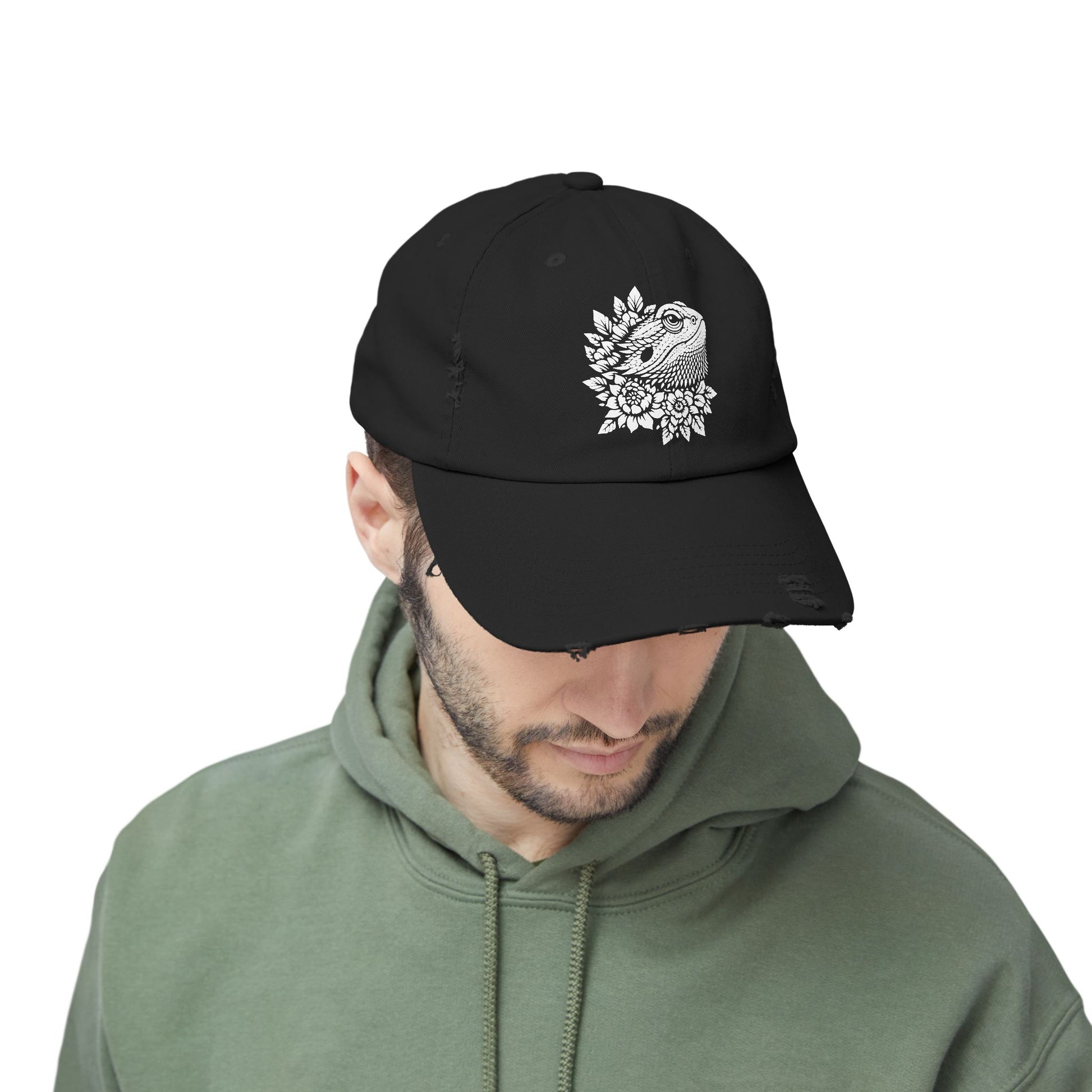 A man wearing a black baseball cap with a white floral design on it.