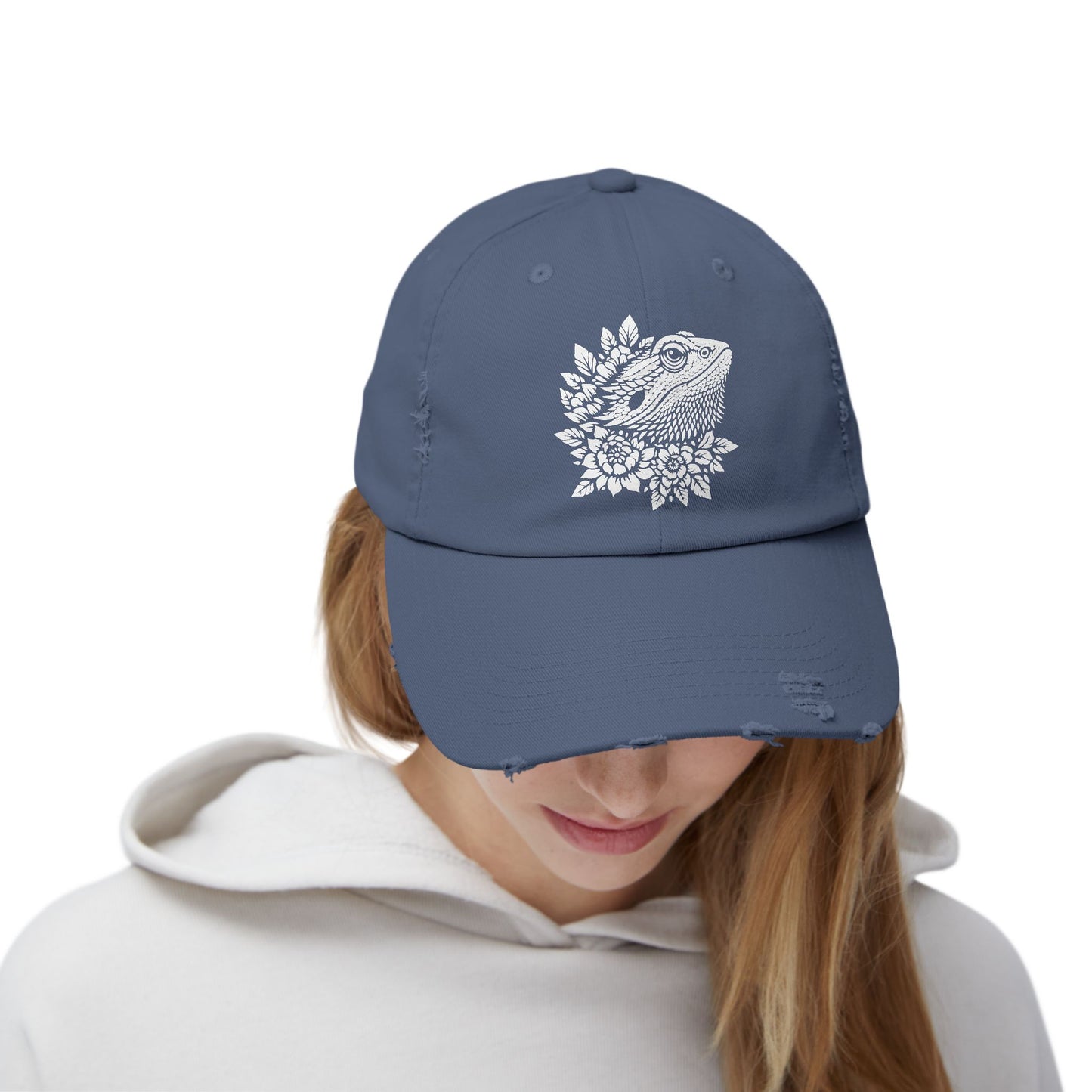 A person wearing a blue baseball cap with a white floral design on the front.